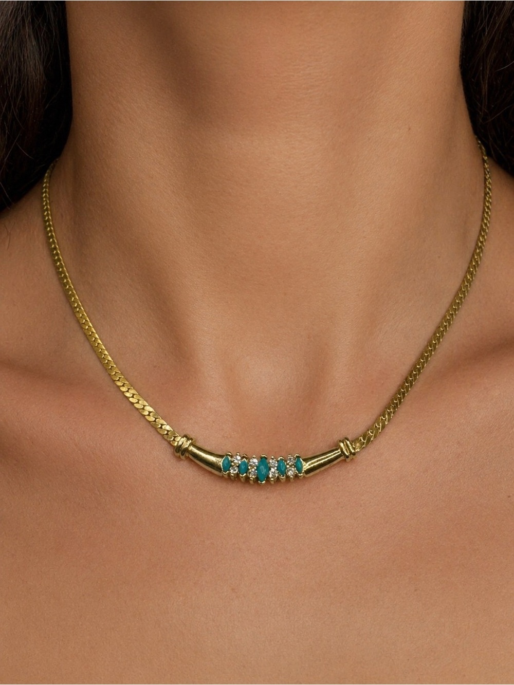 Flat snake style chain Goldtone necklace with a center pendant. 17.5 inches.